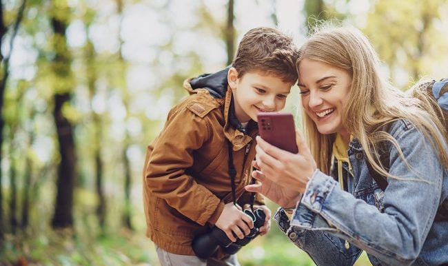 mère et son fils regarde cellulaire dans la foret