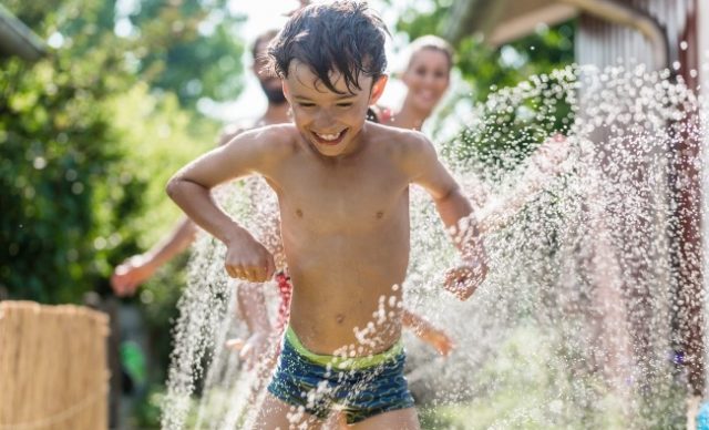 enfant se fait arroser par boyau