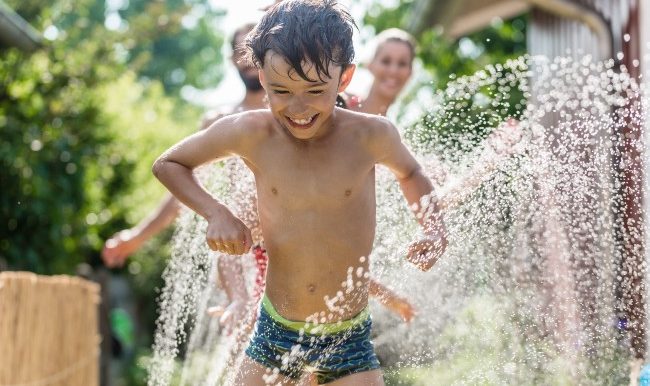 enfant se fait arroser par boyau