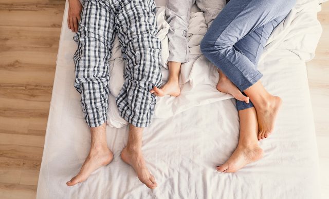 Parents et enfants qui paressent dans un lit
