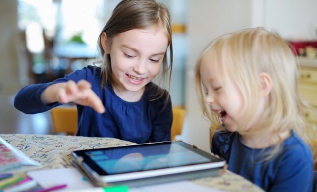 deux enfants devant une tablette électronique