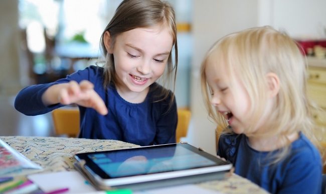 deux enfants devant une tablette électronique