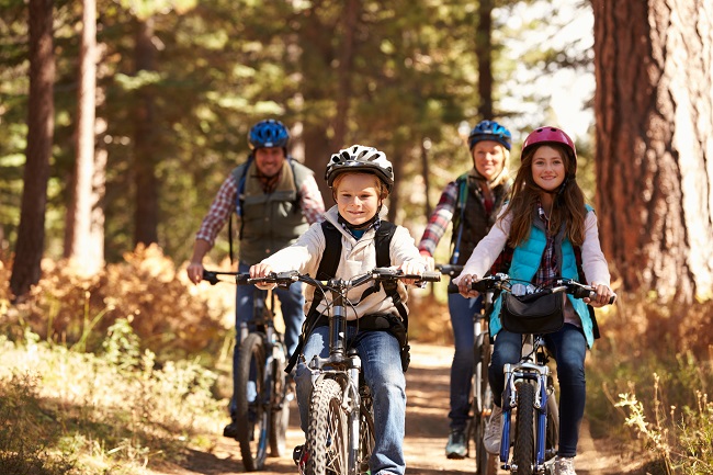 garçon qui fait du vélo de montage avec sa soeur et ses parents