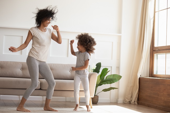 une mère et sa fllle dansent dans le salon