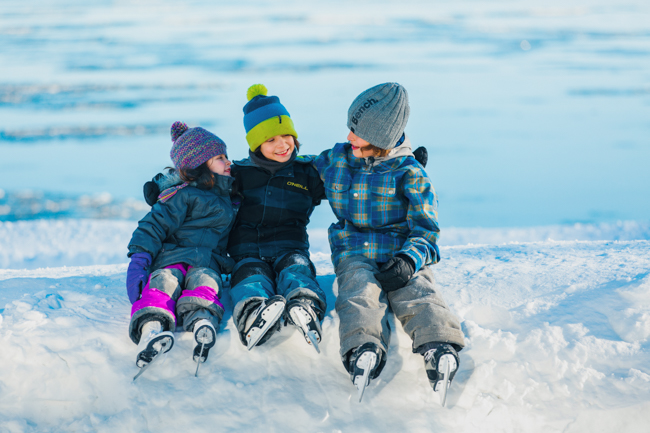 enfants en patin assient sur un banc de neigeur 