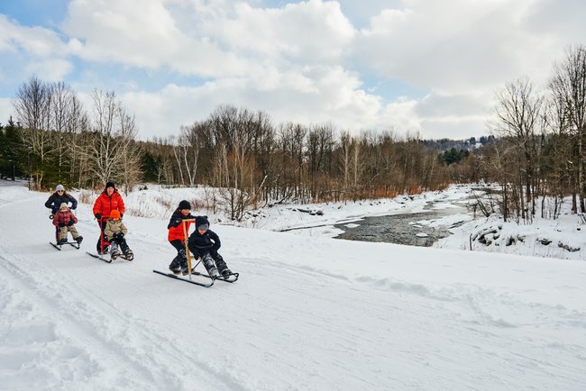 famille en trottinette des neiges
