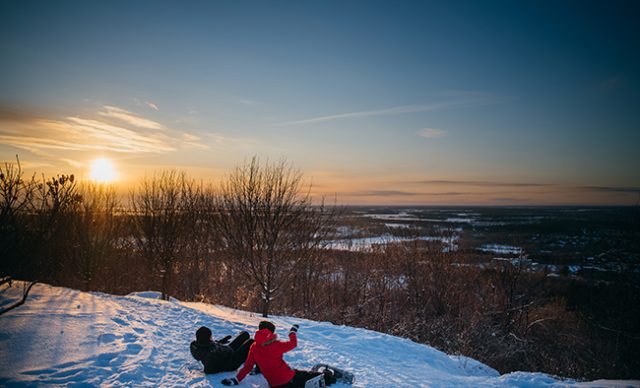 gens qui regardent le coucher du soleil en hiver