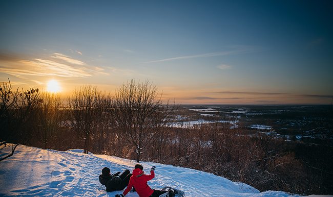 gens qui regardent le coucher du soleil en hiver