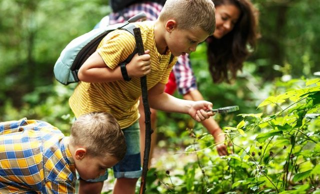 mere et ses fils qui font une randonnee dans la foret