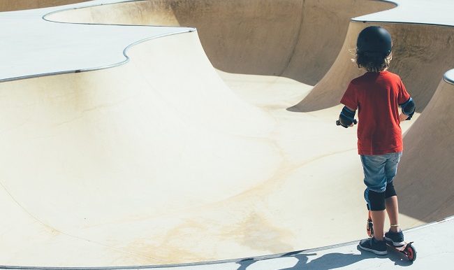 Enfant en trottinette dans le skate park urbain