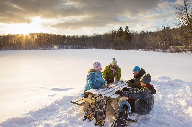 Famille assise à une table de pique nique en hiver