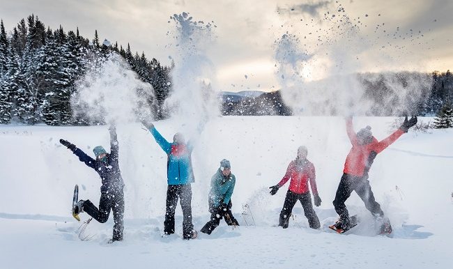 gens heureux pratiquant la raquette à neige
