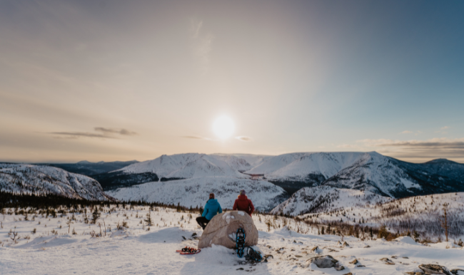 coouple en raquette d'hiver qui observe le couche du soleil