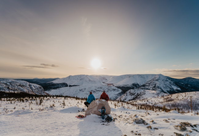 coouple en raquette d'hiver qui observe le couche du soleil