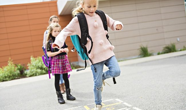 eleves qui s'amusent à la marelle dasn une cour d'école