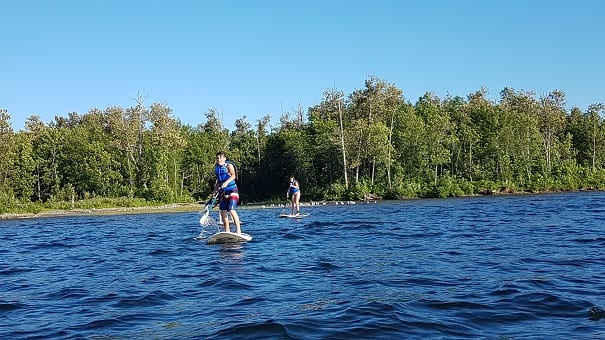 Adolescents en SUP sur un plan d'eau